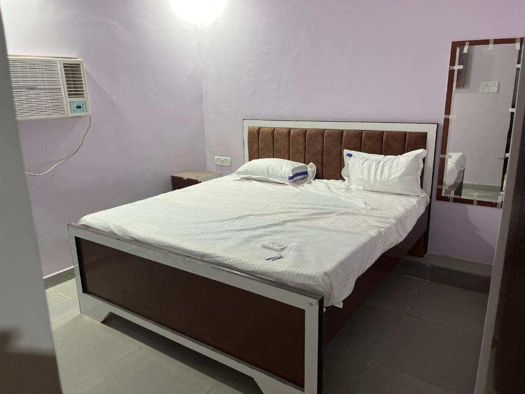 a bed in a small room with a fan at Hotel Anusuiya palace in Lucknow