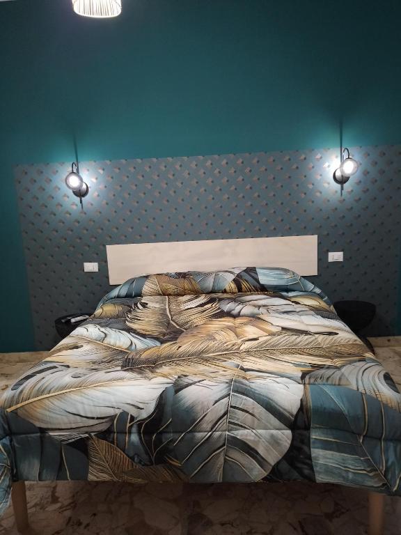 a bed in a bedroom with two lights above it at Nonno Turiddu Elegant Rooms in Caccamo