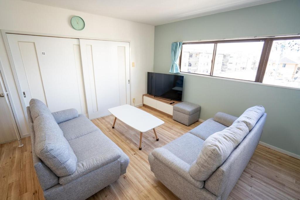 a living room with two couches and a tv at マンションルミエールＩ301 rumiereＩ301 in Gifu