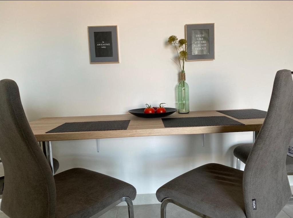 a wooden table with chairs and a vase of flowers on it at Deck 3 in Cuxhaven