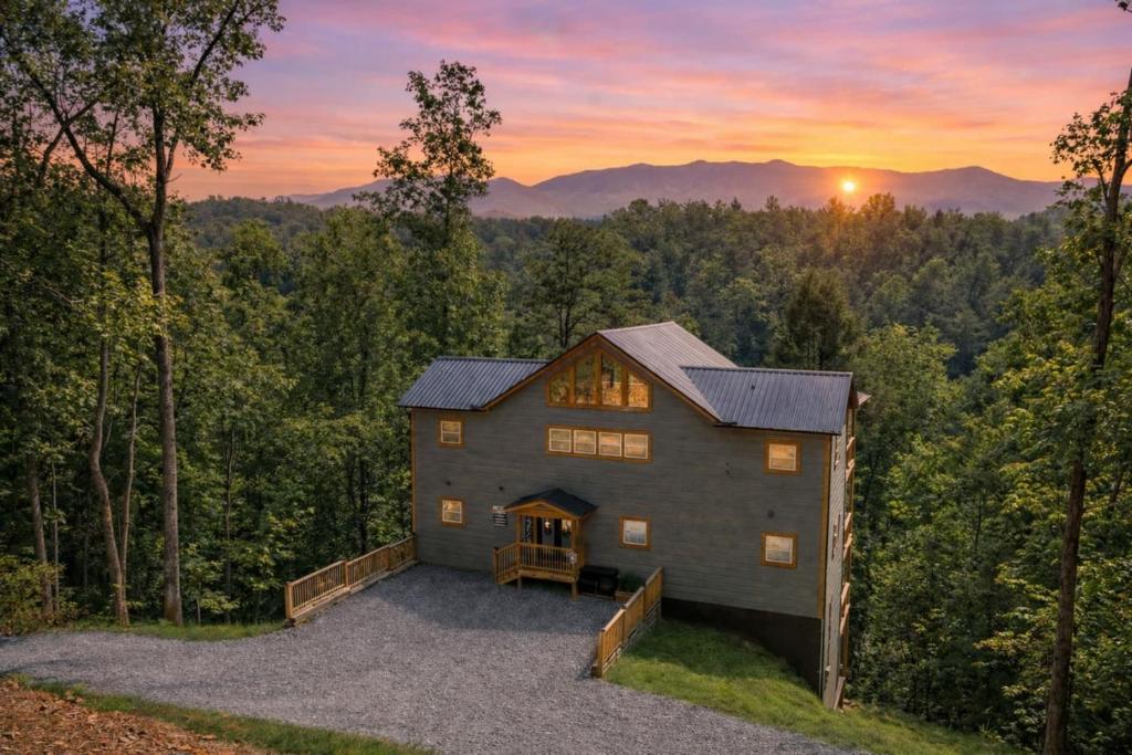 a barn house in the woods at sunset at Luxe Mountain Pool Escape by Ghosal Luxury Lodging in Gatlinburg
