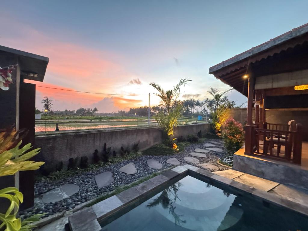 a pool in the backyard of a house with a sunset at Uma Sunset Villa in Ubud