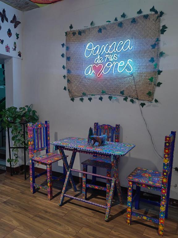 a table with chairs and a sign that saysaca do this authors at Casa los Arcos Oaxaca in Oaxaca City