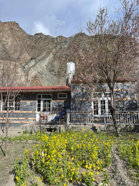 an old stone house with a mountain in the background at Village Homestay in Chalt
