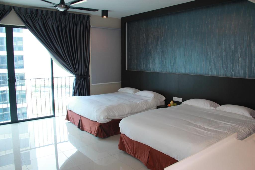una camera d'albergo con due letti e una grande finestra di Setia Inn Suites Service Residence a Setia Alam