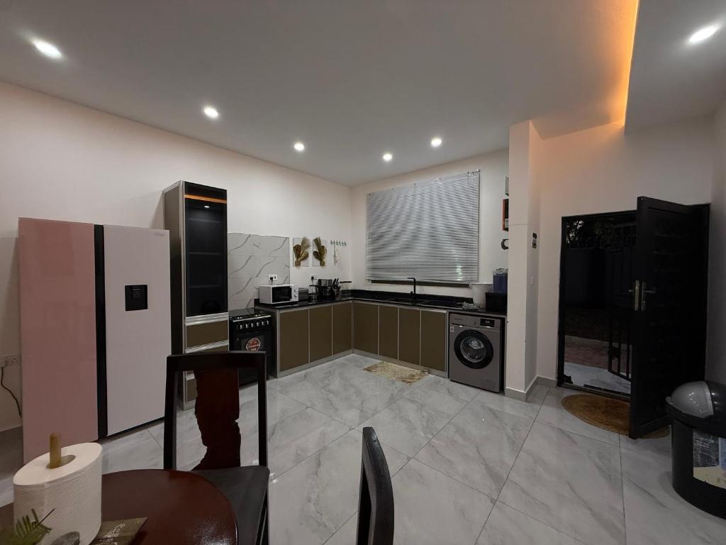 a large kitchen with a refrigerator and a stove at Samash villas 2 in Lusaka