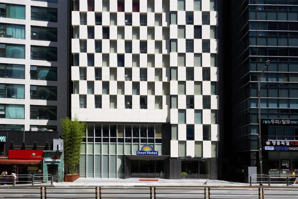 a tall black and white building in a city at Days Hotel by Wyndham Seoul Myeongdong in Seoul