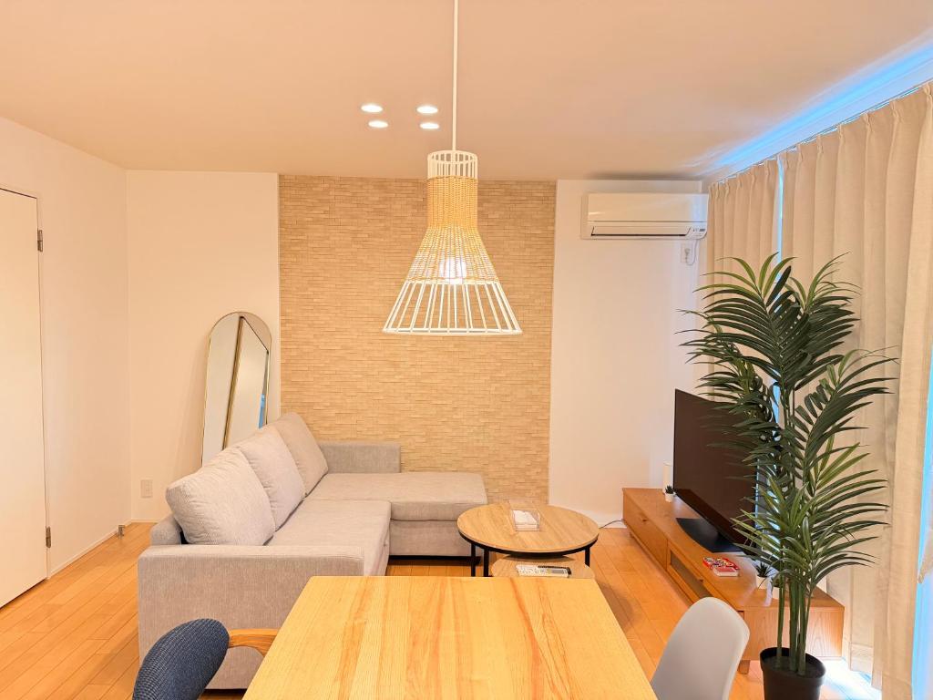 a living room with a couch and a tv at Franmare in Okayama