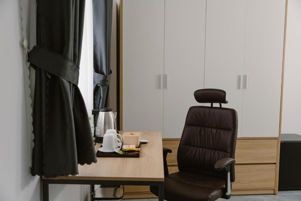 a chair sitting next to a table and a desk with a chair at SmartCity Hometel in Can Tho