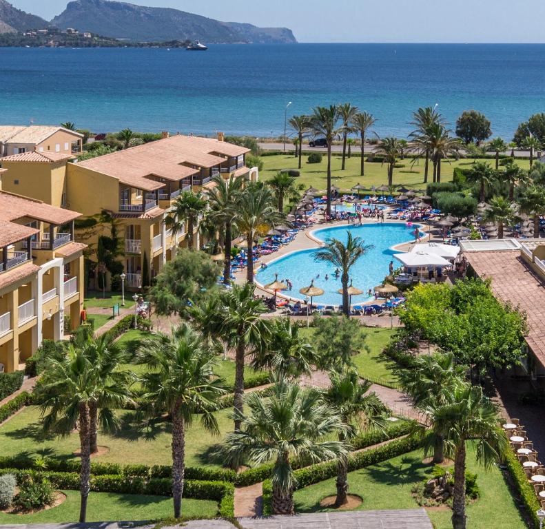 an aerial view of a resort with a pool and the ocean at Club del Sol Aparthotel in Port de Pollensa