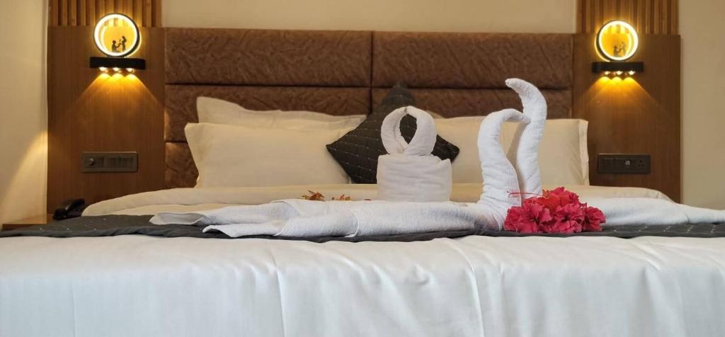 a bed with white towels and flowers on it at Corbett Hill Site in Rāmnagar