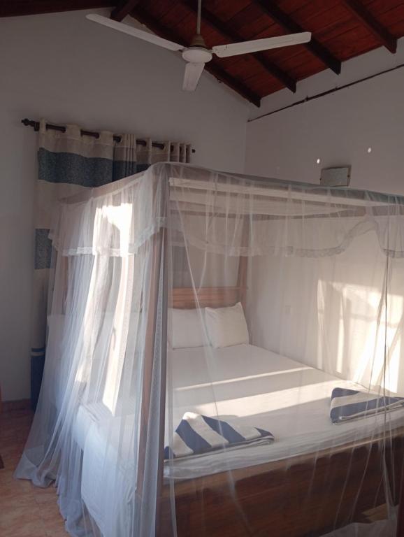 a white bed with a canopy in a room at 39 House Weligama in Weligama