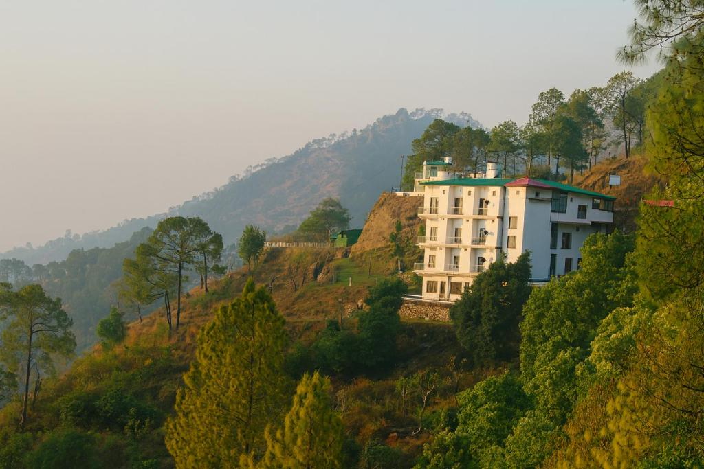 a building on top of a hill with trees at Maavaa Dreamland in Lansdowne