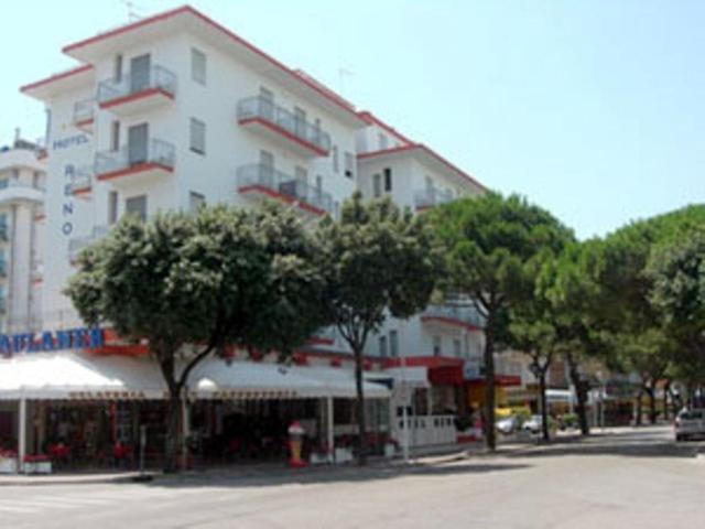 a large white building with trees in front of it at Hotel Reno in Lido di Jesolo