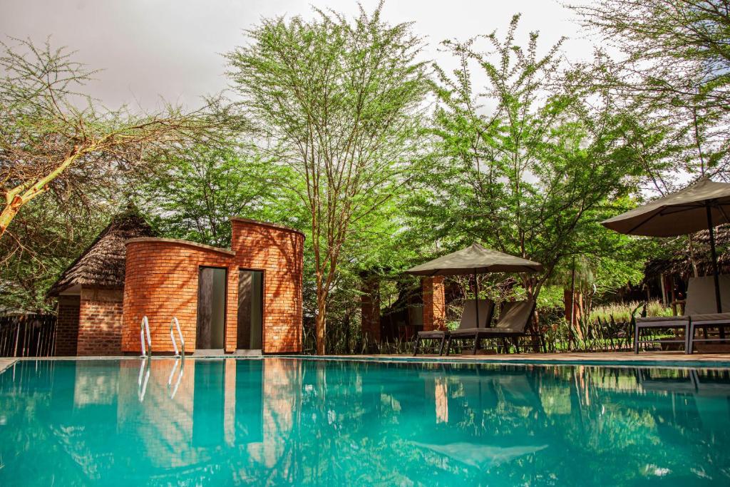 a resort with a swimming pool and a house at Kutoka Lodge in Arusha