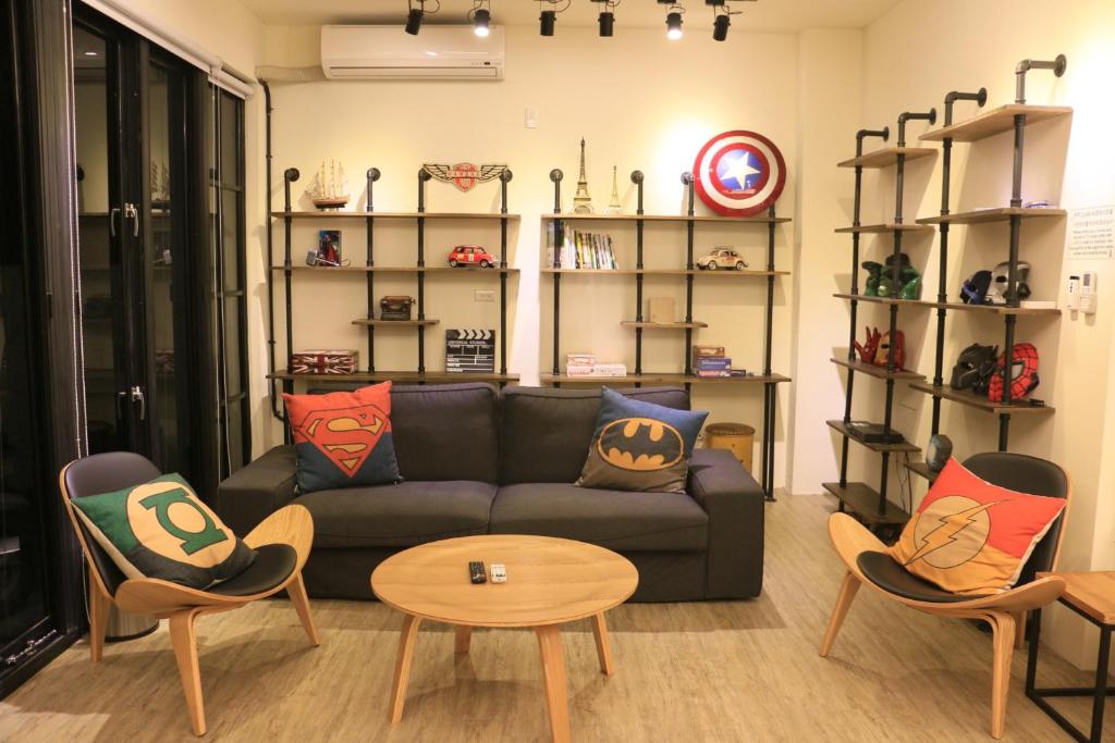 a living room with a couch and a table and chairs at Here Hostel Puli in Puli