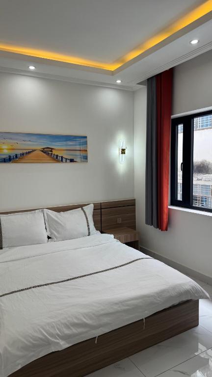 a bedroom with a large bed and a window at Furaton Hotel in Ðức Hòa