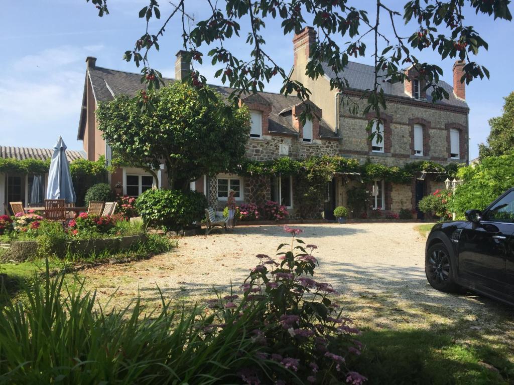 a house with a car parked in front of it at Demeure Saint Gildas in La Haye-Pesnel