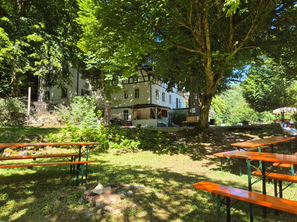 a group of picnic tables in a park with a building at Zeitinsel Doos in Waischenfeld