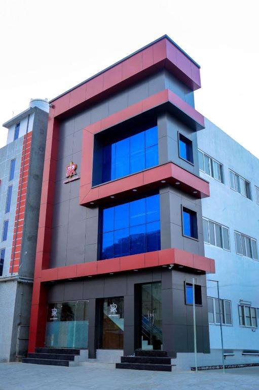 a building with blue windows in front of it at RUBY Residency in Palni