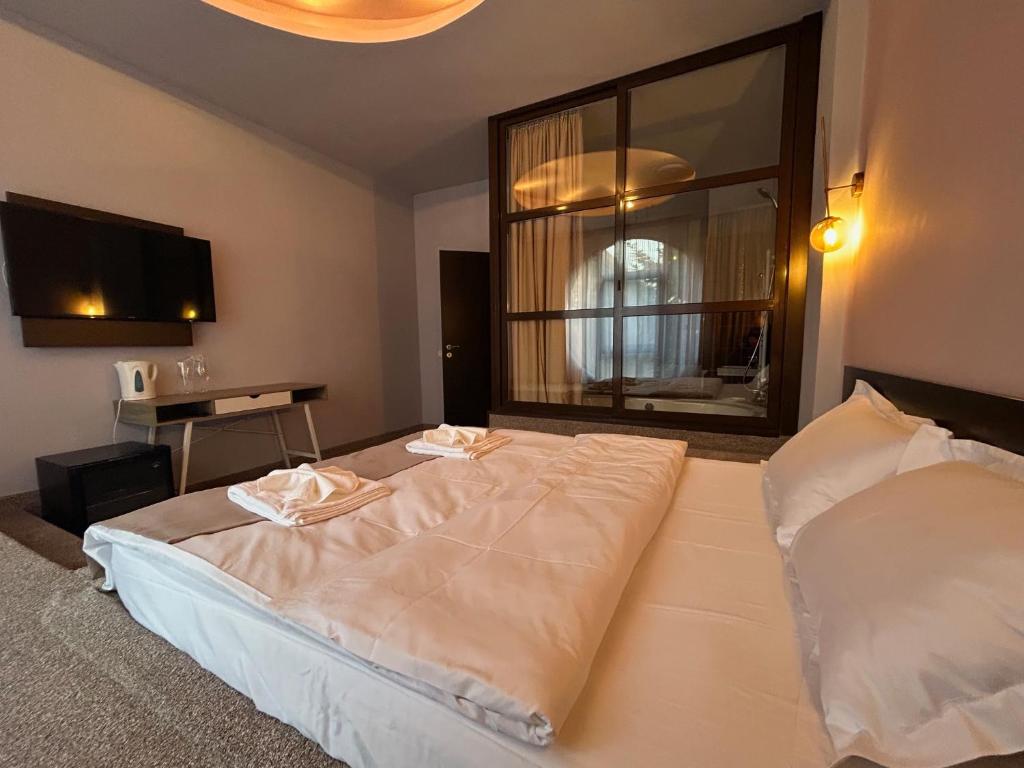 a bedroom with a large bed and a window at Hotel Artimino in Timişoara