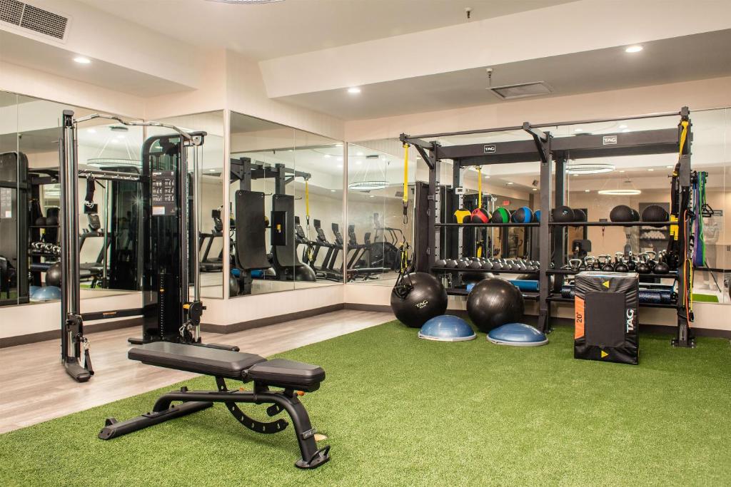 a gym with lots of exercise equipment and a green rug at Hilton Garden Inn Clackamas Portland in Clackamas