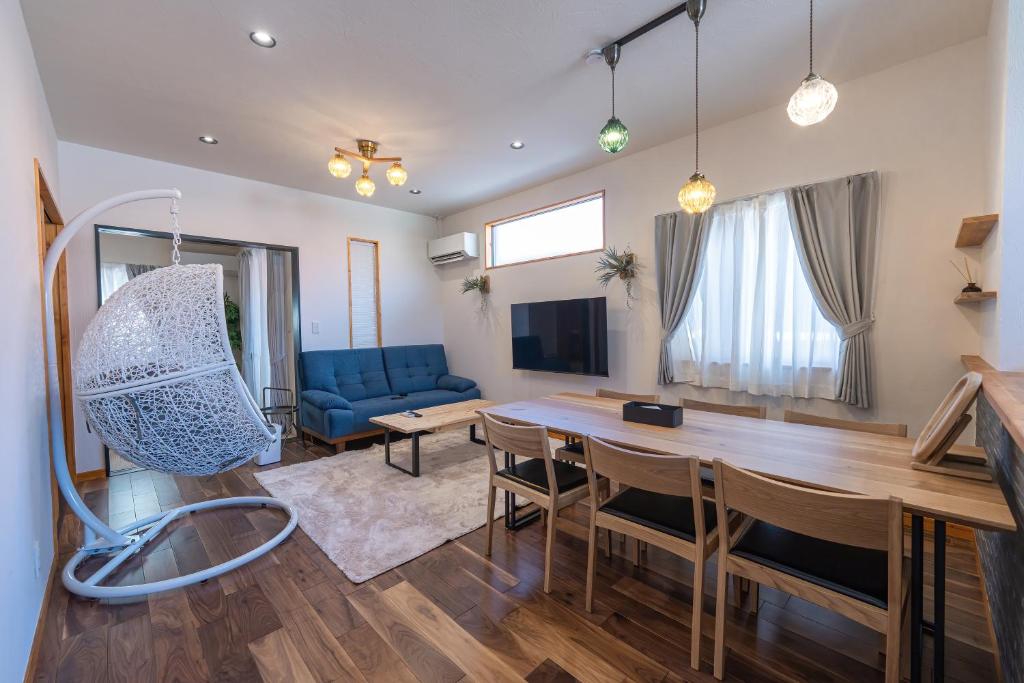 a living room with a table and a blue couch at Miyako Island Breeze in Miyako-jima