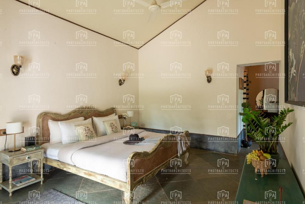 a bedroom with a large bed and a table at Fable by RÊVE Escapes - Premium 3 BHK Villa Near Vagator Beach in Assagao
