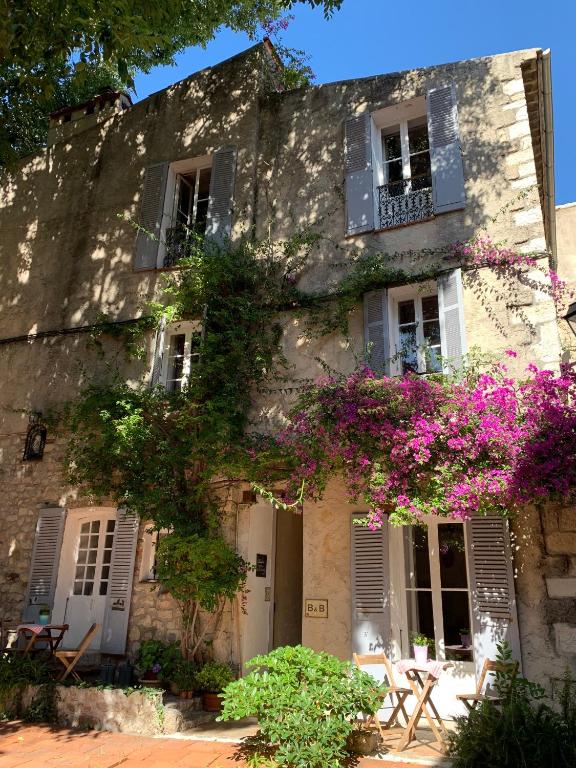 an old stone building with purple flowers and windows at La Clé de la Porte Rentals in Antibes