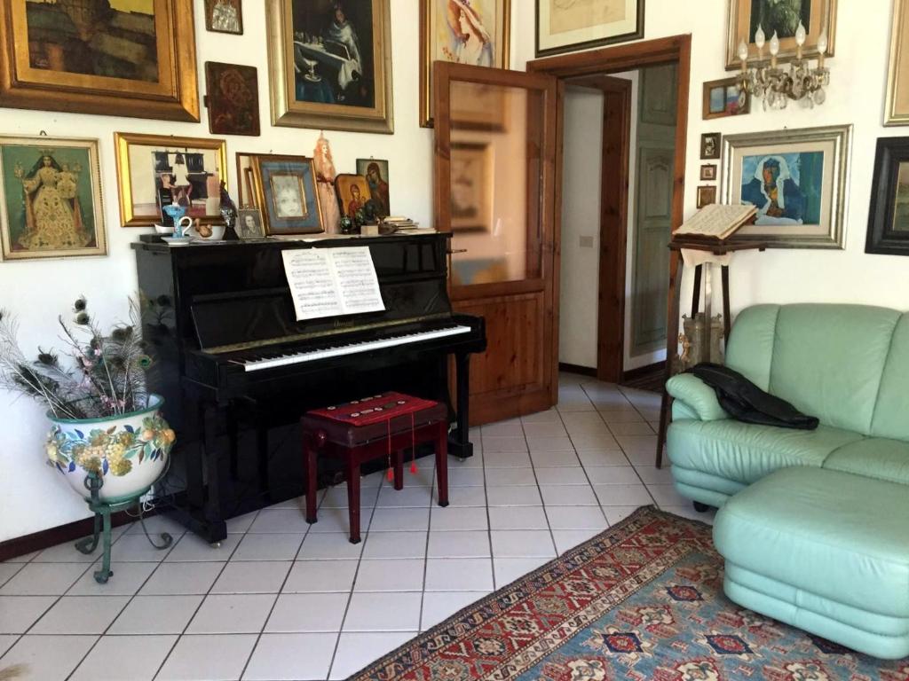 a living room with a piano and a couch at La Chiave di Violino in Olbia