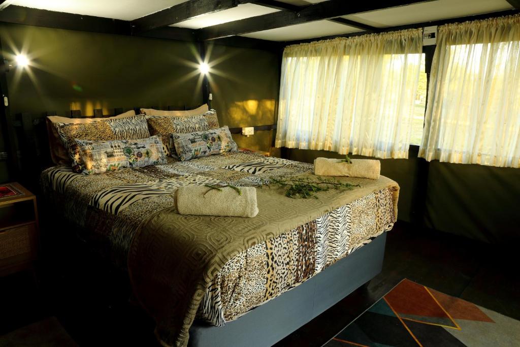 a bedroom with a large bed with pillows at Thorn Tree Bush Camp in Klipdrift