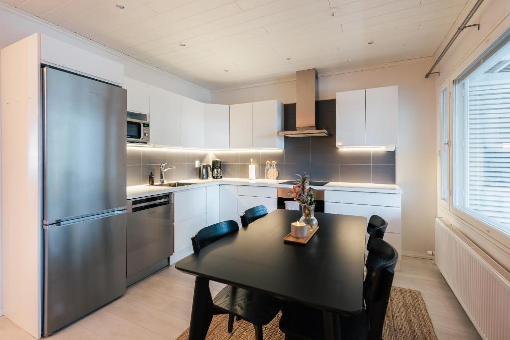 a kitchen with a black table and a refrigerator at Arctic Circle Holiday Homes in Rovaniemi