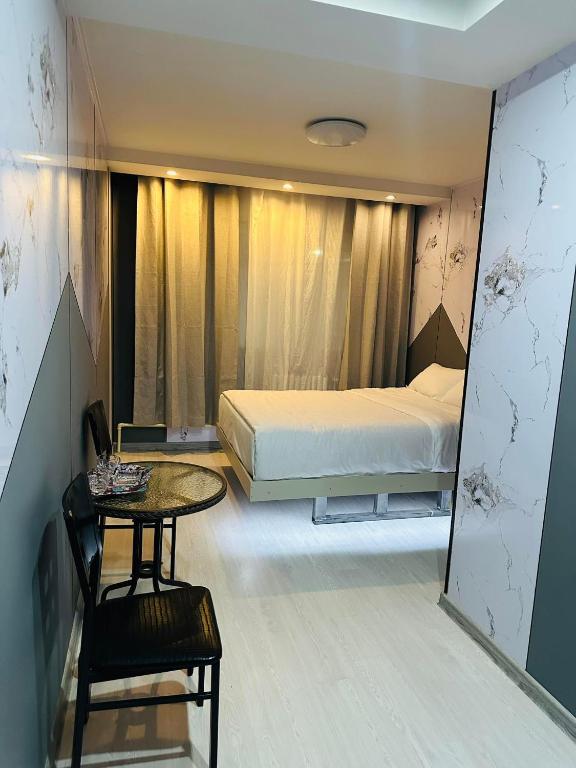 ein Schlafzimmer mit einem Bett, einem Tisch und einem Stuhl in der Unterkunft Emoji Hotel in Ongon
