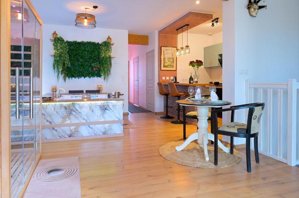 a dining room and kitchen with a table and chairs at Echappée Nocturne in Saint-Privat