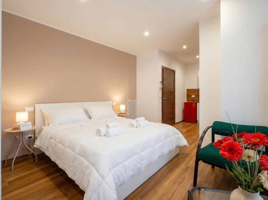 a bedroom with a large white bed and a green chair at Bengasi Central Loft in Stazione Bari Centrale