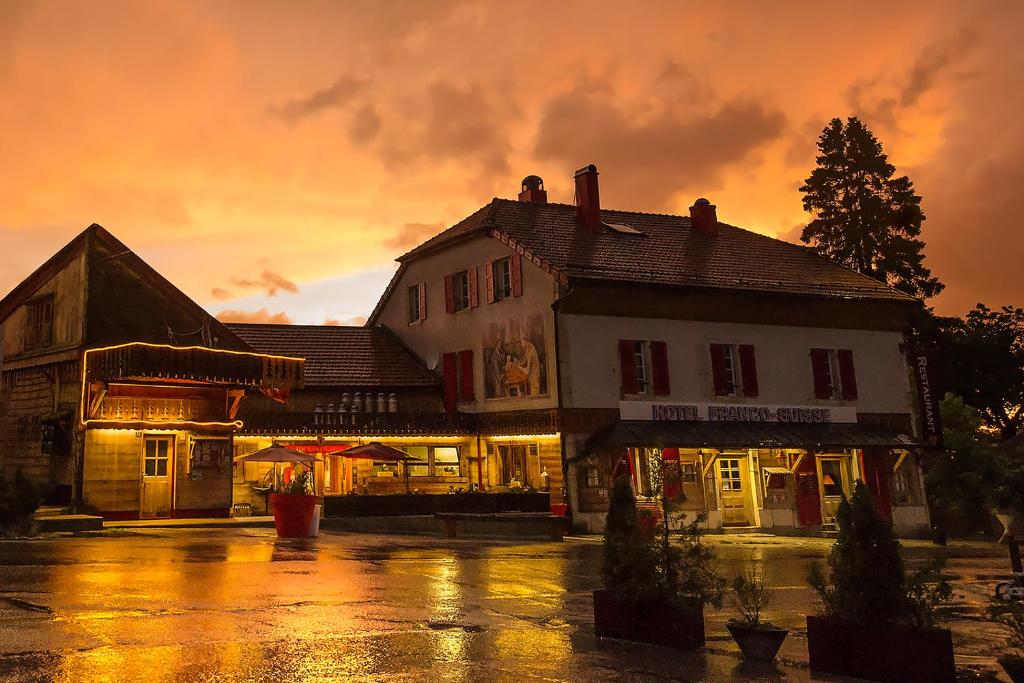 a building on a rainy street with a sunset at L'ARBEZIE Franco Suisse in Les Rousses