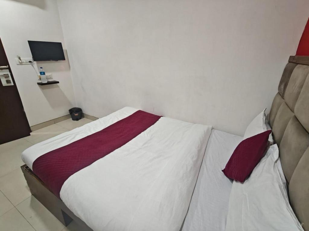 a bedroom with a bed with white and red sheets at Hotel Silver Shine Jogeshwari in Mumbai
