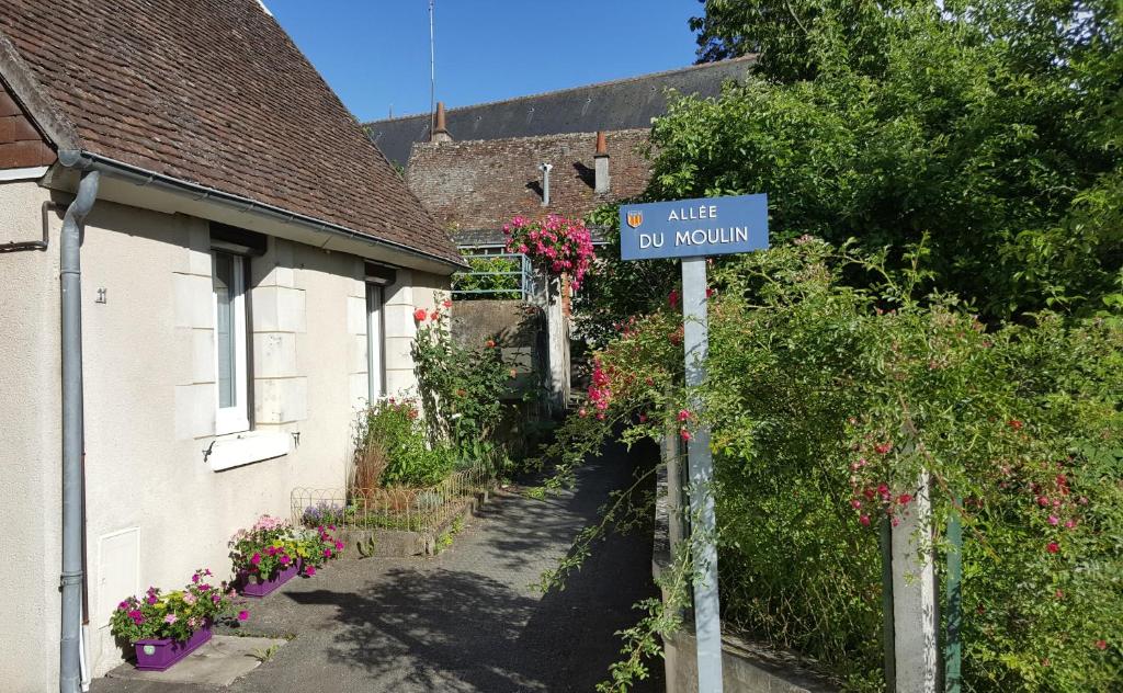 un panneau de rue devant une maison fleurie dans l'établissement La Petite Lucette, à Amboise