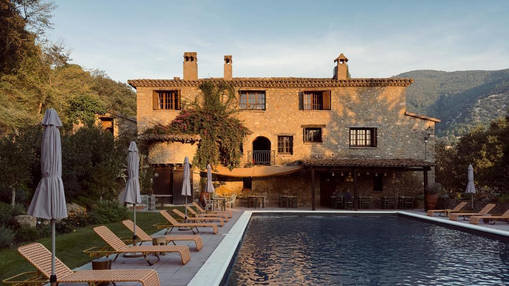 ein Haus mit einem Swimmingpool vor einem Gebäude in der Unterkunft Off Grid Girona in Beuda