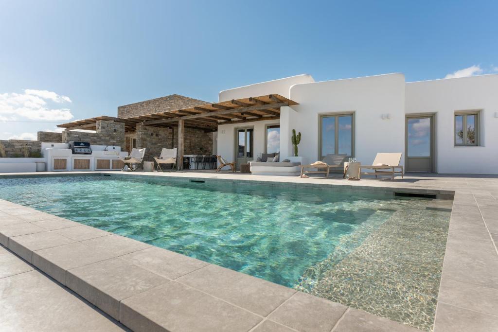 a villa with a swimming pool and a house at Lolantonis - 3BR Sea View & Infinity Pool - Thymari in Aspro Chorio Paros