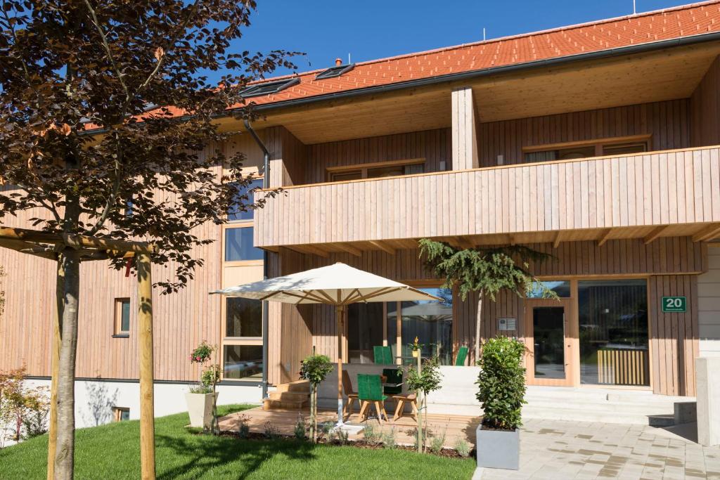 an external view of a building with an umbrella at Genuss-Pension Herti in Übelbach