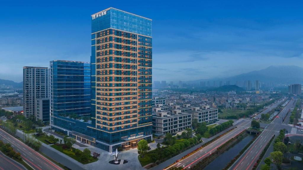 a tall skyscraper with a view of a city at Maison New Century Ninghai Railway Station in Ninghai