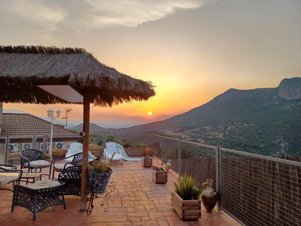 a patio with a table and chairs and a sunset at Casa Sofia in Ubrique