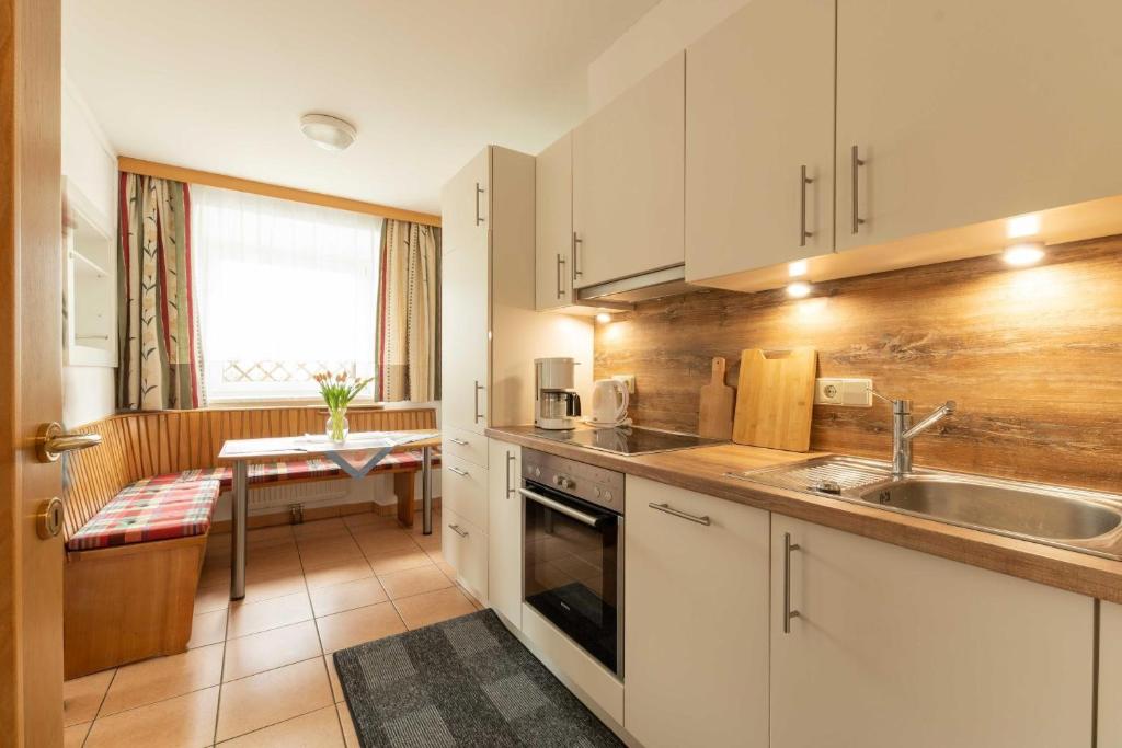 a kitchen with white cabinets and a sink at Appartment Isabelle Terra in Lake Pressegg