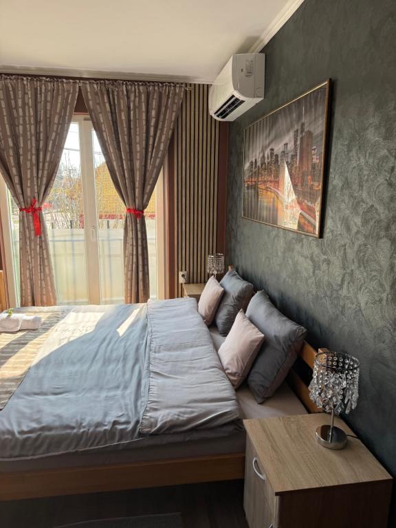 a bedroom with a large bed in front of a window at Vila Alexandra 2025 in Bačka Topola
