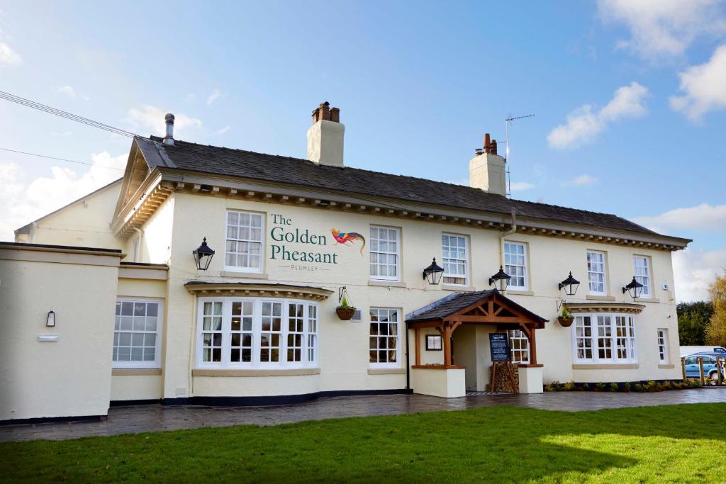 a white building with a sign that reads the golden princess at The Golden Pheasant in Knutsford