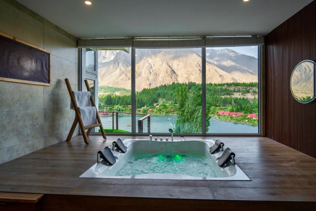 a bathroom with a tub with a view of a mountain at Tibet Hotel in Skardu