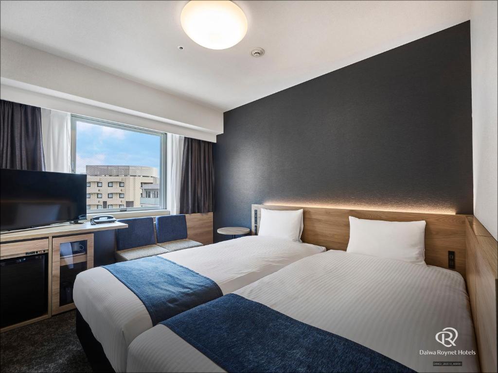 a hotel room with two beds and a television at Daiwa Roynet Hotel Tokyo Akabane in Tokyo