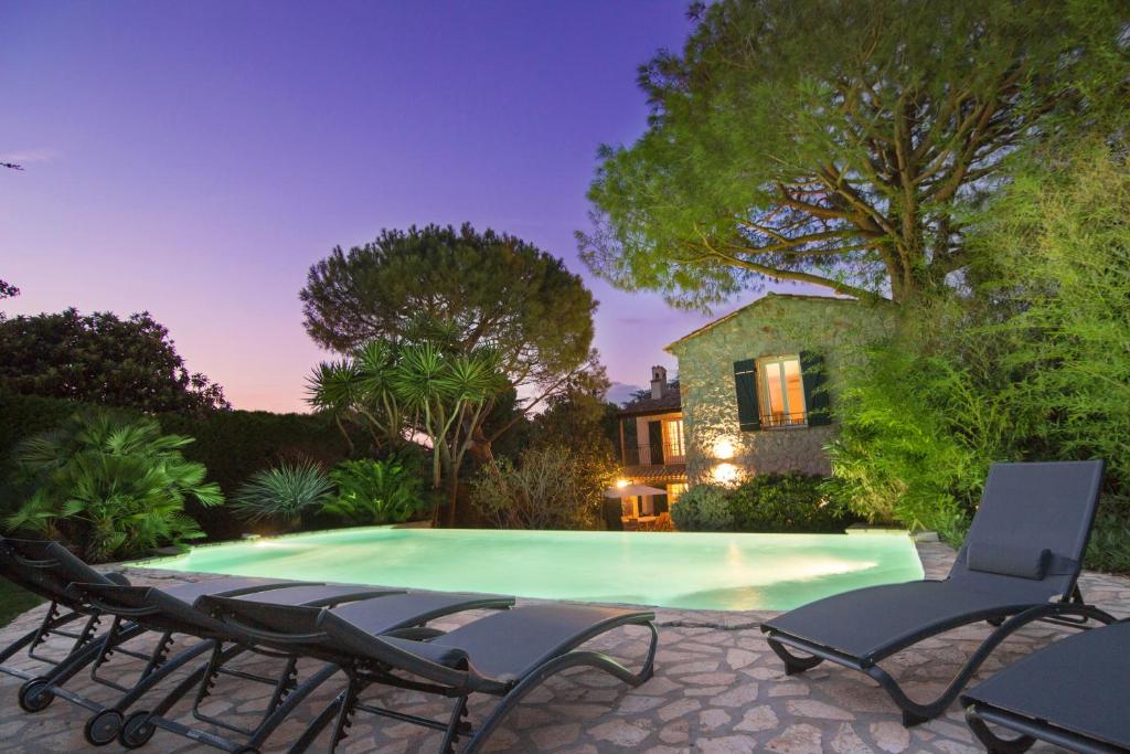 a swimming pool with chairs and a house at Villa Vuyani Antibes in Antibes