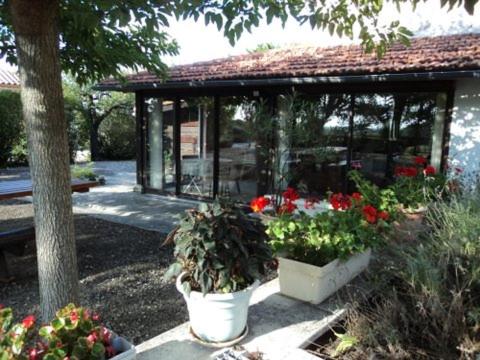 a gazebo with two pots of flowers in a garden at Le Moulin in Sauzet